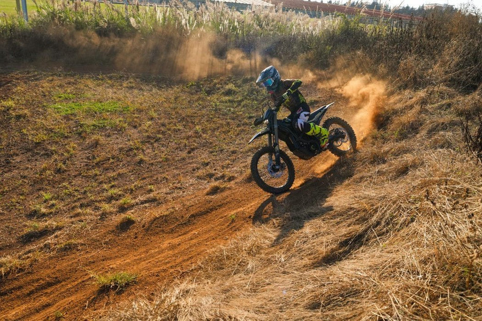Rider na Sur-Ron Ultra Bee pędzi po zakurzonym zakręcie na torze enduro